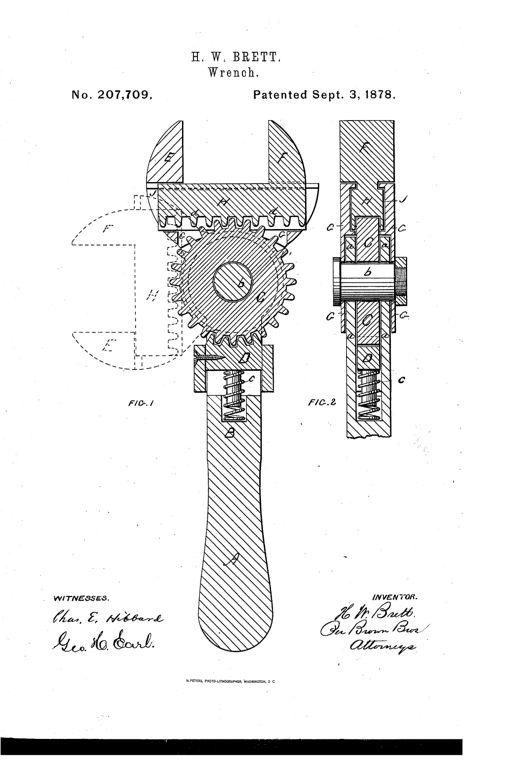 Patent drawing of an adjustable wrench with a long handle, showing an internal pinion gear meshing with a toothed rack on one jaw, and a spring-loaded pawl block visible in cross-section, with dashed lines indicating the jaws swung to alternate positions.